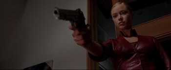 Movie still from “Terminator 3: Rise of the Machines” (2003), directed by Jonathan Mostow – A woman is holding a gun in a room; Medium shot, Low angle