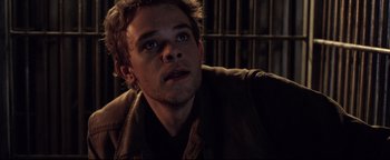 Movie still from “Terminator 3: Rise of the Machines” (2003), directed by Jonathan Mostow – A man with a beard is looking at the camera; Close Up shot, Low angle