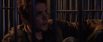 Movie still from “Terminator 3: Rise of the Machines” (2003), directed by Jonathan Mostow – A person behind a fence; Close Up shot, High angle