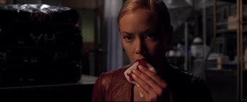 Movie still from “Terminator 3: Rise of the Machines” (2003), directed by Jonathan Mostow – A beautiful young lady holding a piece of food; Close Up shot, Over the shoulder angle