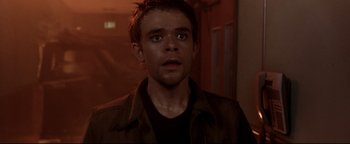 Movie still from “Terminator 3: Rise of the Machines” (2003), directed by Jonathan Mostow – A person wearing a brown jacket; Close Up shot, Over the shoulder angle