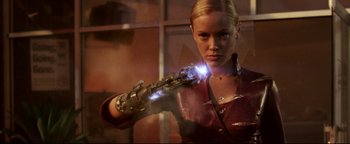 Movie still from “Terminator 3: Rise of the Machines” (2003), directed by Jonathan Mostow – A woman is holding a glowing object in her hand; Medium shot, Low angle