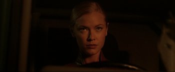 Movie still from “Terminator 3: Rise of the Machines” (2003), directed by Jonathan Mostow – A beautiful woman with blonde hair and green eyes; Close Up shot, Over the shoulder angle