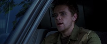 Movie still from “Terminator 3: Rise of the Machines” (2003), directed by Jonathan Mostow – A person sitting in a car looking at the camera; Close Up shot, Low angle