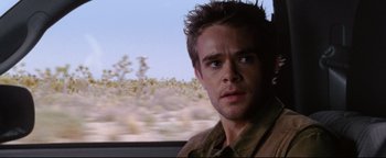 Movie still from “Terminator 3: Rise of the Machines” (2003), directed by Jonathan Mostow – A person in a car; Close Up shot, Over the shoulder angle