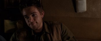 Movie still from “Terminator 3: Rise of the Machines” (2003), directed by Jonathan Mostow – A young man is smiling for the camera; Close Up shot, Over the shoulder angle