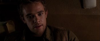 Movie still from “Terminator 3: Rise of the Machines” (2003), directed by Jonathan Mostow – A man's face in a dark room; Close Up shot, Over the shoulder angle