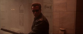 Movie still from “Terminator 3: Rise of the Machines” (2003), directed by Jonathan Mostow – A person wearing sunglasses and a leather jacket; Medium shot, Low angle
