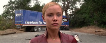 Movie still from “Terminator 3: Rise of the Machines” (2003), directed by Jonathan Mostow – A woman with blonde hair wearing a red jacket; Close Up shot, Low angle