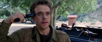 Movie still from “Terminator 3: Rise of the Machines” (2003), directed by Jonathan Mostow – A young man with a headset on his head; Close Up shot, High angle
