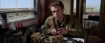 Movie still from “Terminator 3: Rise of the Machines” (2003), directed by Jonathan Mostow – A man sitting at a table holding a cell phone; Close Up shot, Low angle