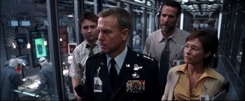 Movie still from “Terminator 3: Rise of the Machines” (2003), directed by Jonathan Mostow – A group of men standing next to each other in a room; Medium shot, Over the shoulder angle