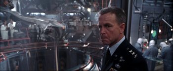 Movie still from “Terminator 3: Rise of the Machines” (2003), directed by Jonathan Mostow – A person wearing a military uniform; Medium shot, Over the shoulder angle