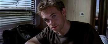 Movie still from “Terminator 3: Rise of the Machines” (2003), directed by Jonathan Mostow – A person sitting down; Close Up shot, High angle