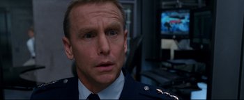 Movie still from “Terminator 3: Rise of the Machines” (2003), directed by Jonathan Mostow – A person wearing a uniform; Close Up shot, Over the shoulder angle