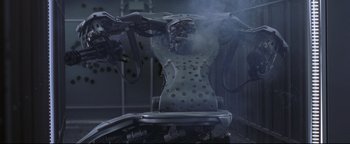 Movie still from “Terminator 3: Rise of the Machines” (2003), directed by Jonathan Mostow – An industrial machine with steam coming out of it; Medium shot, Overhead angle
