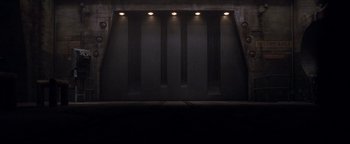 Movie still from “Terminator 3: Rise of the Machines” (2003), directed by Jonathan Mostow – A dark room with lights on the walls; Extreme Wide shot, Low angle