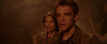 Movie still from “Terminator 3: Rise of the Machines” (2003), directed by Jonathan Mostow – A man and a woman standing next to each other; Close Up shot, Over the shoulder angle