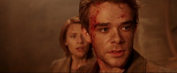 Movie still from “Terminator 3: Rise of the Machines” (2003), directed by Jonathan Mostow – A man and a woman with blood all over their faces; Close Up shot, Over the shoulder angle