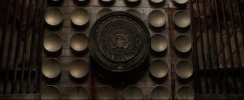 Movie still from “Terminator 3: Rise of the Machines” (2003), directed by Jonathan Mostow – A plaque on the wall of the united states of america; Wide shot, Low angle