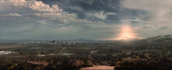 Movie still from “Terminator 3: Rise of the Machines” (2003), directed by Jonathan Mostow – A view of a city from a hill with a cloudy sky; Extreme Wide shot, High angle
