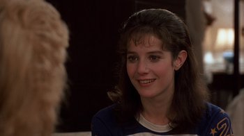 Movie still from “Terms of Endearment” (1983), directed by James L. Brooks – A young woman smiles while sitting in front of a mirror; Close Up shot, Over the shoulder angle