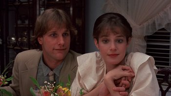 Movie still from “Terms of Endearment” (1983), directed by James L. Brooks – A man and a woman sitting next to each other in front of flowers; Close Up shot, Over the shoulder angle