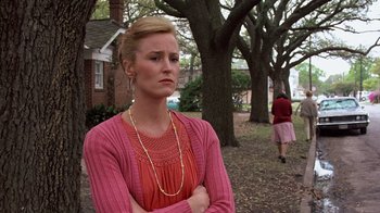 Movie still from “Terms of Endearment” (1983), directed by James L. Brooks – A woman standing in front of a tree with her arms crossed; Medium shot, Over the shoulder angle