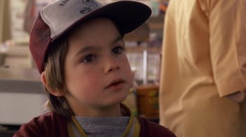 Movie still from “Terms of Endearment” (1983), directed by James L. Brooks – A little boy wearing a hat and looking to his left; Close Up shot, Over the shoulder angle