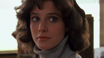 Movie still from “Terms of Endearment” (1983), directed by James L. Brooks – A person wearing a sweater and looking at the camera; Close Up shot, Low angle