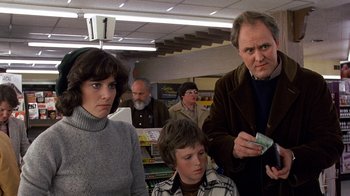 Movie still from “Terms of Endearment” (1983), directed by James L. Brooks – A group of people standing around each other in a room; Medium shot, Over the shoulder angle