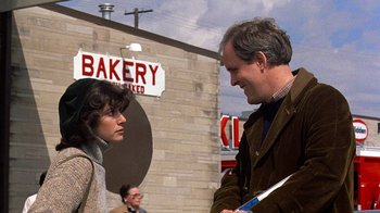 Movie still from “Terms of Endearment” (1983), directed by James L. Brooks – A man and a woman are talking outside a bakery; Medium shot, Over the shoulder angle