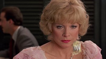 Movie still from “Terms of Endearment” (1983), directed by James L. Brooks – An older woman holding a fork in front of her face; Close Up shot, Over the shoulder angle