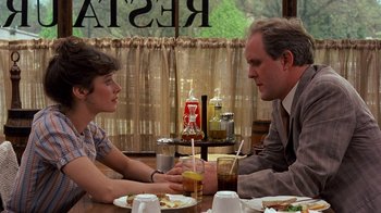 Movie still from “Terms of Endearment” (1983), directed by James L. Brooks – A man and a woman sitting at a dinner table; Medium shot, Over the shoulder angle