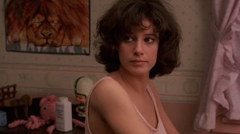 Movie still from “Terms of Endearment” (1983), directed by James L. Brooks – A young woman with brown curly hair sitting in a room; Close Up shot, Low angle