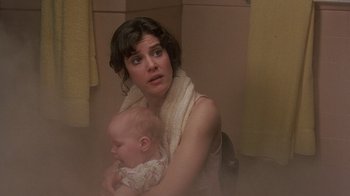 Movie still from “Terms of Endearment” (1983), directed by James L. Brooks – A woman holding a baby in her arms in a bathroom; Close Up shot, Low angle