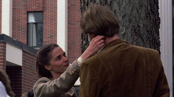 Movie still from “Terms of Endearment” (1983), directed by James L. Brooks – A woman putting a collar on a man's neck; Medium shot, Over the shoulder angle