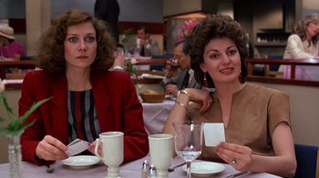 Movie still from “Terms of Endearment” (1983), directed by James L. Brooks – Two women sitting at a table with wine glasses; Medium shot, Over the shoulder angle