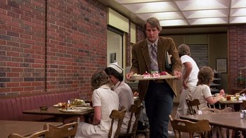 Movie still from “Terms of Endearment” (1983), directed by James L. Brooks – A man carrying a tray of food in a restaurant; Medium shot, Over the shoulder angle