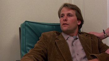 Movie still from “Terms of Endearment” (1983), directed by James L. Brooks – A man sitting in a chair with his head tilted to the side; Close Up shot, Over the shoulder angle