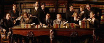 Movie still from “Thank You for Smoking” (2005), directed by Jason Reitman – A group of men sitting at a table in front of books; Wide shot, High angle