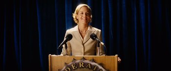 Movie still from “Thank You for Smoking” (2005), directed by Jason Reitman – A woman standing at a podium with two microphones; Medium shot, Low angle