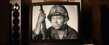 Movie still from “Thank You for Smoking” (2005), directed by Jason Reitman – A man holding a rifle in front of a television; Close Up shot, Low angle