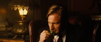 Movie still from “Thank You for Smoking” (2005), directed by Jason Reitman – A man in a suit eating a piece of food; Close Up shot, High angle