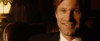 Movie still from “Thank You for Smoking” (2005), directed by Jason Reitman – A person wearing a suit and smiling; Close Up shot, Over the shoulder angle