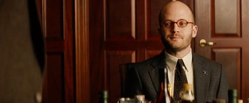 Movie still from “Thank You for Smoking” (2005), directed by Jason Reitman – A man sitting at a table in front of a bottle of wine; Close Up shot, Low angle