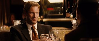 Movie still from “Thank You for Smoking” (2005), directed by Jason Reitman – A man sitting at a table with a glass of red wine; Close Up shot, Over the shoulder angle