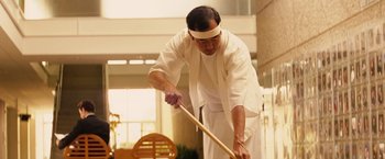 Movie still from “Thank You for Smoking” (2005), directed by Jason Reitman – A man holding a wooden stick while wearing a white outfit; Medium shot, Low angle