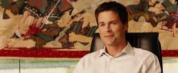 Movie still from “Thank You for Smoking” (2005), directed by Jason Reitman – A person sitting in a chair in front of a painting; Close Up shot, Over the shoulder angle