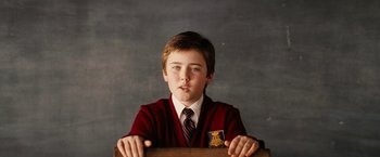 Movie still from “Thank You for Smoking” (2005), directed by Jason Reitman – A young boy in a red sweater and a tie; Close Up shot, Low angle